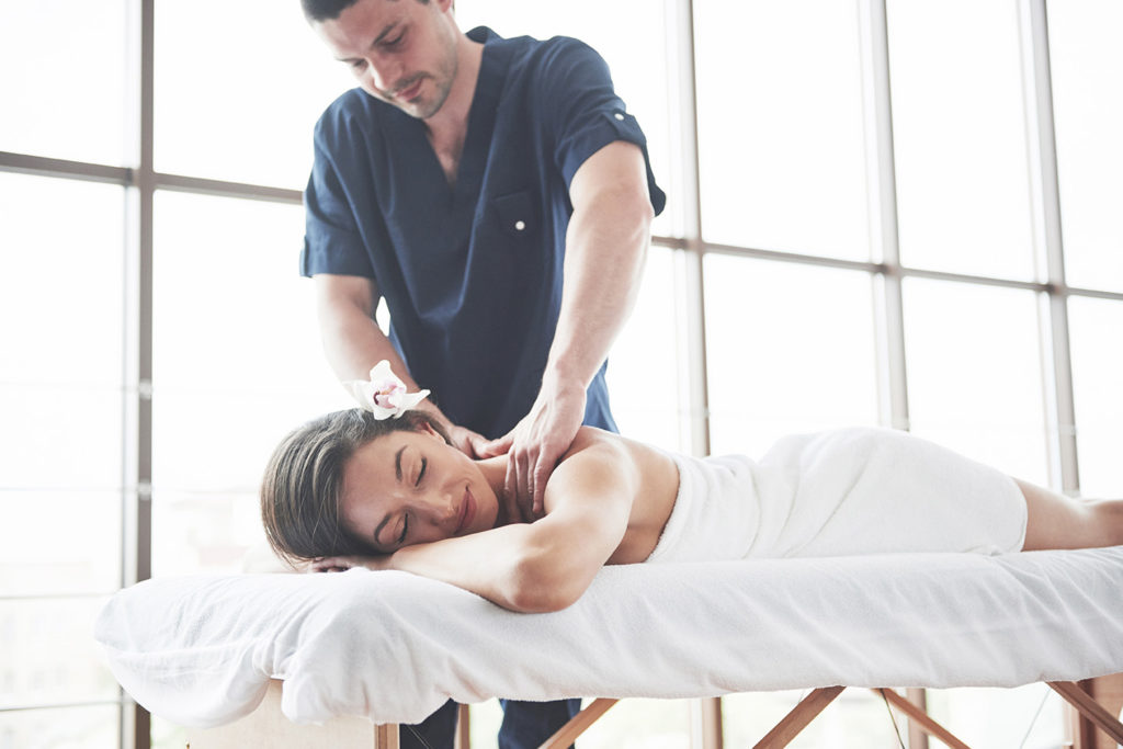 Woman lying on a massage table and receiving a massage